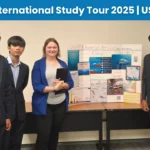 TIA Students with their project display board, joined by a faculty member.